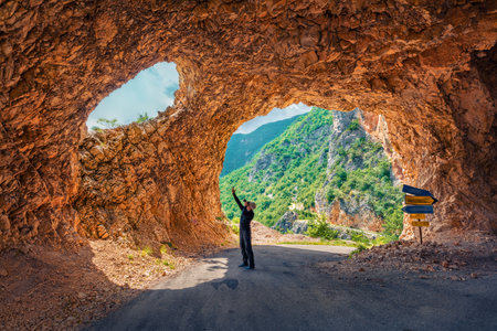Photographer takes picture in tunel to Piva river pass. Bright summer day in Montenegro, Europe. Travel concept background.の写真素材