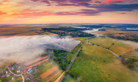aerial landscape photography. View from flying drone of misty Ukrainian countryside. Breathtaking summer sunrise on outskirts of Ternopil town, Ukraine, Europe. Travel concept background.の写真素材