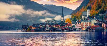 Panoramic morning cityscape of Hallstatt village, in Austria's mountainous Salzkammergut region, Austria. Great autumn sunrise on Hallstatt lake. Travel concept background.の写真素材