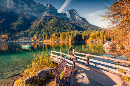 Sunny autumn view of Hintersee lake with wooden pier and fishing boat. Stunning morning view of Bavarian Alps, Germany, Europe. Travel concept background.の写真素材