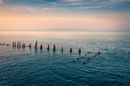 Remains of an old wooden pier in Durres, port city on the Adriatic Sea in western Albania, Europe. Picturesque Adriatic seascape with endless horizon. Calm spring scene of Albania.の写真素材