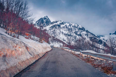 Huge snowdrifts on the sides on road to mountains. Dramatic spring scene of Theth National Park, Albania, Europe. April in Albanian highlands. Travel concept background.の写真素材