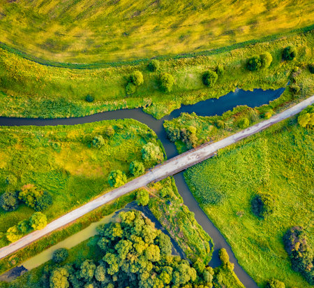 Straight dawn view from flying drone of bridge over small river, Ternopil region, Ukraine, Europe. Fresh green scene of flooded valley. Beauty of nature concept background.の写真素材