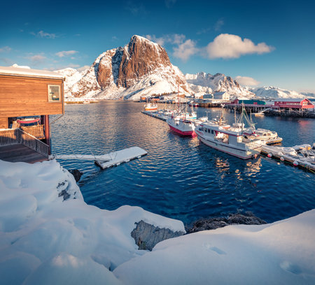 Splendid afternoon on Hamnoy port with Festhaeltinden mount on background, Norway, Europe. Snowy morning scene of Lofoten Islands. Amazing winter seascape of Norwegian sea.の写真素材