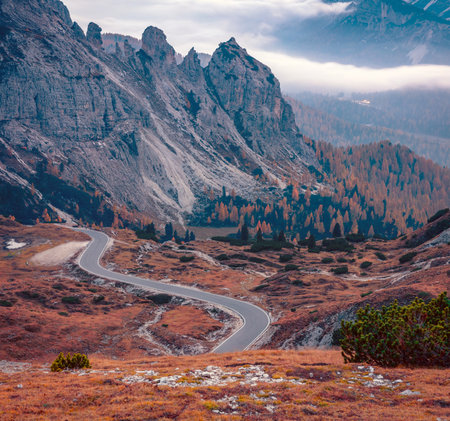 Foggy autumn view of Tre Cime Di Lavaredo National Park with winding road. Dramatic evening scene of Dolomite Alps, Auronzo Di Cadore location, Italy, Europe. beauty of nature concept background.の写真素材