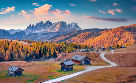 Adorable autumn view of winding road on Fuchiade valley. Wonderful evening view of Dolomite Alps, Italy, Europe. Spectacular sunset in Italy, Europe. Beauty of countryside concept background.の写真素材