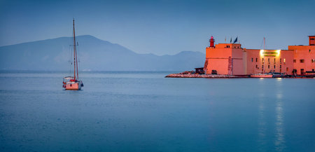 Panoramic evening cityscape of Gaeta town with yacht and lighthouse. Calm summer sunset on the coast...