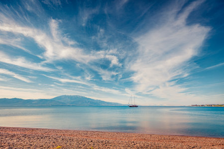 Beautiful spring view of Nafpaktos public beach with yacht on background. Sunny morning scene of the Gulf of Corinth, Greece, Europe. Travel concept background.の写真素材