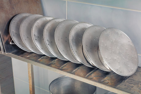 A small family cheese factory in the Carpathian village. Metal covers for cheese molds.の写真素材