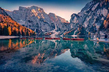 Photo shoot on the shore of Braies Lake with recreational boats. Calm autumn scene of Dolomite Alps, Italy, Europe. Travel concept background.の写真素材