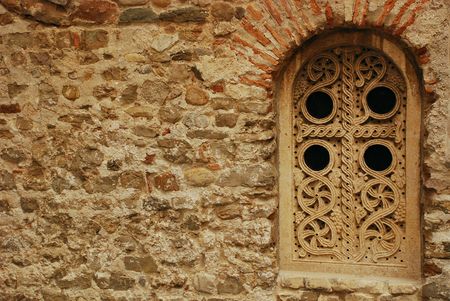 A window in an old church in central Albenga with beautiful carved details 