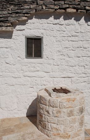The wall of a traditional trullo house in Alberobello with a small window in it. The Trulli of Alberobello are protected as a UNESCO World Heritage site.  の写真素材
