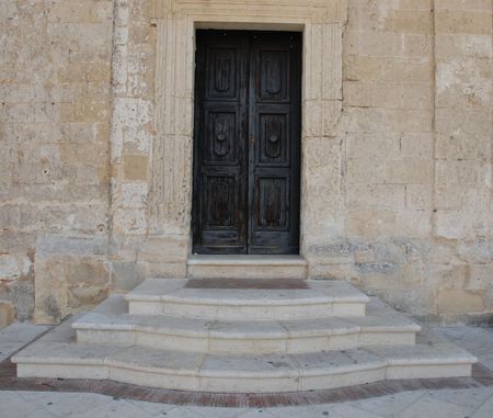 A black door with steps at the entrance of a house in Matera, southern Italy の写真素材