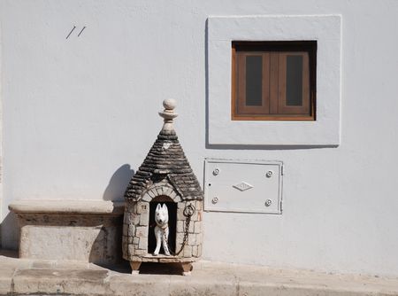 A pretend dog hut outside a traditional trulli houses in Alberobello in Puglia, southern Italy. The trulli, which are protected under UNESCO World Heritage laws, are traditional limestone houses with domed or conical roofs, and are common in the Alberobelの写真素材