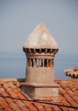 A chimney on a tiled rooftop in the historic Slovenian coastal town of Piranの写真素材