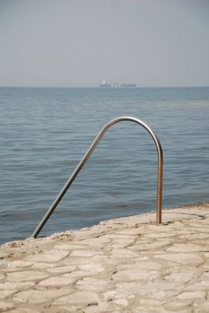 A rail for swimmers lead down into the Mediterranean waters at the coast of the historic Slovenian town of Izolaの写真素材