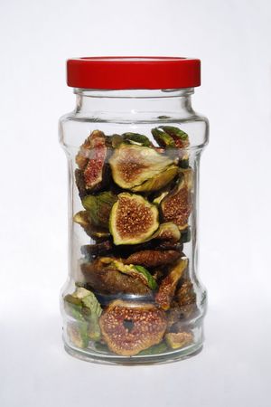 Dried figs in a glass jar against a white backgroundの写真素材