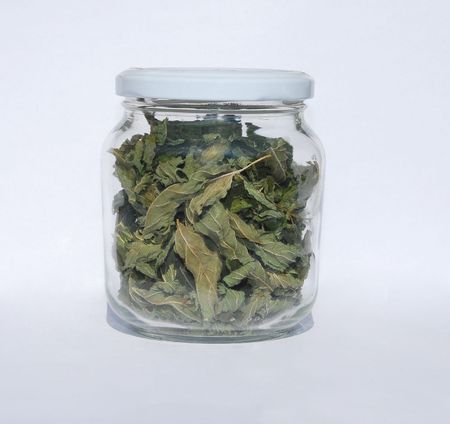 A glass jar of dried peppermint leaves の写真素材