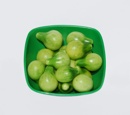 A green bowl containing green under-ripe yellow pear tomatoes (sometimes known as Beam's Yellow Pear) の写真素材