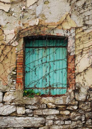 A closed green-shuttered window in the north east Italian village of Postachの写真素材