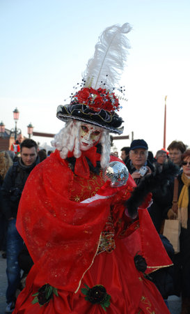 Venice, Italy, 02.21.09: A carnival goer in red holding a small silver disco ball at the Venice Carnivalのeditorial素材