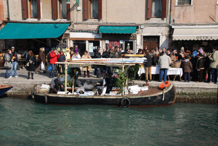 Venice, Italy, 02.21.09: Customers queue for food at a boat cooking and selling freshly fried fish at the Venice Carnivalのeditorial素材