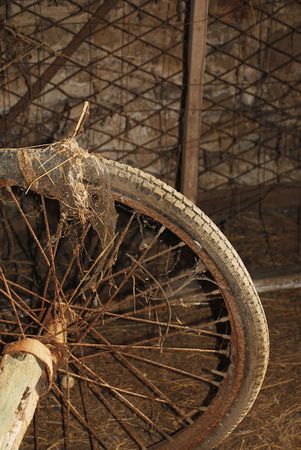 A wheel of a nineteenth century wooden animal-pulled cart in a derelict Italian farm buildingの写真素材