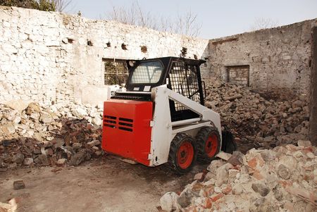 A skid steer loader in a partially demolished derelict old Italian farm buildingの写真素材