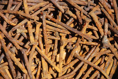 A pile of old nails, rusted after having been in contact with water, in natural daylightの写真素材