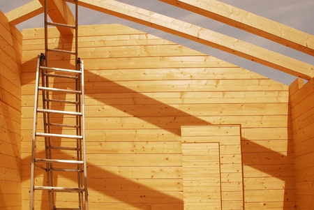 A ladder and empty door frames in a partially constructed wood (fir) block house, a pre-cut wooden house which is assembled on-site の写真素材