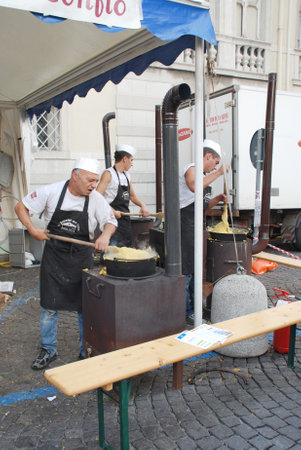 Udine, Italy -  September 17th 2011 -  Chefs stirring polenta on a polenta stall during the 2011 annual Friuli Doc celebration of locally produced food, drinks and craftsのeditorial素材