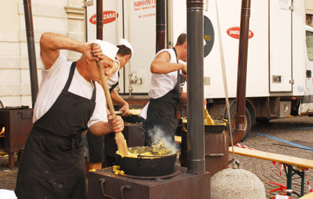 Chefs stirring polenta on a polenta stall during the 2011 annual Friuli Doc (Udine, Italy, 17th September 2011) celebration of locally produced food, drinks and craftsのeditorial素材