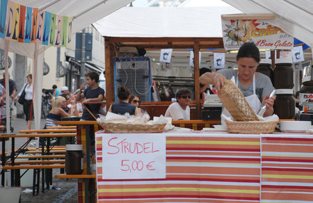 Udine, Italy, September 17th 2011. A woman fills a serving basket with freshly made strudels on a strudel stall during the 2011 annual Friuli Doc celebration of locally produced food, drinks and craftsのeditorial素材
