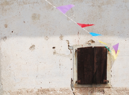 A window in a village in Friuli, north east Italy  The building is decorated with bunting in celebration of the annual village fete の写真素材