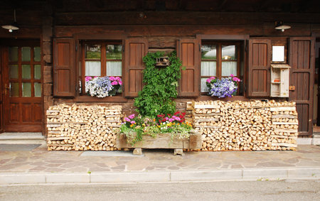 An old wooden in a north eastern Italian village  Wood is stacked outside ready for winter burningのeditorial素材