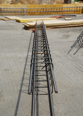 Steel reinforcement cage used in the construction of building foundations  The foundation site is surrounded by wooden shuttering and the steel cages are in the process of being laid out before the concrete is pouredの写真素材