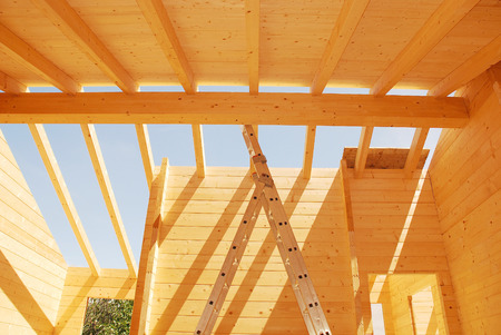Roof construction on a partially constructed wood  fir  block house, a pre-cut wooden house which is assembled on-siteの写真素材