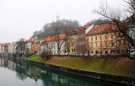 Buildings on Cankarjevo Nabrejze along the banks of the Ljubljanica River in central Ljubljana at Christmas. Ljubljana Castle can be seen in the background on the hill.のeditorial素材