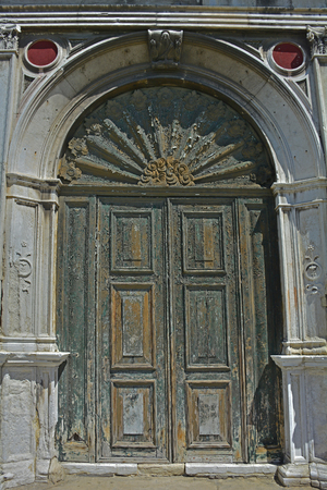 An old wooden door in a derelict building in the Dorsoduro quarter of Veniceの写真素材