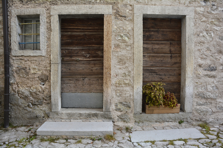 Old wooden doors in disused buildings the historic hill village of Erto in Friuli Venezia Giulia, north east Italyの写真素材