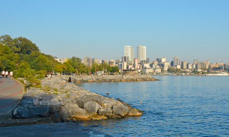 Istanbul, Turkey - September 16th 2019. People relax in the late afternoon sun on the waterfront in the Moda district of Kadikoy on Istanbul's Asian shore. The Kiziltoprak district can be seen in the backgroundのeditorial素材