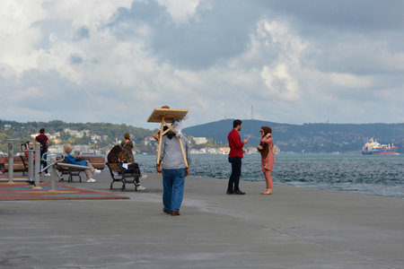 Istanbul, Turkey - September 10th 2019. An itinerant bagel seller walks along the waterfront with at Rumeli Hisari in the Sariyer district of Istanbulのeditorial素材
