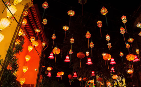 Hoi An, Vietnam - December 20th 2017. Colourful red, orange and pink fabric lanterns hang across a street in the historic UNESCO listed Vietnamese town of Hoi An.のeditorial素材