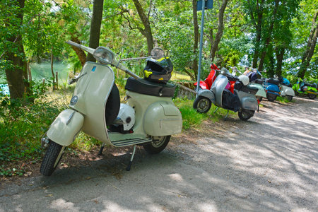 Villaggio di Punta Sdobba, Italy - June 14 2020. Nine Vespas, part of a small rally of Vespa motorikes parked in the wetland area of Isola Della Cona in Friuli-Venezia Giulia, north east Italyのeditorial素材