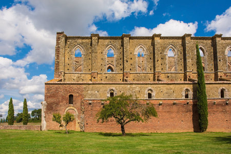 Chiusdino, Italy - 7th September 2020. A side view of the roofless San Galgano Abbey in Siena Province, Tuscany, showing lancet or pointed arch windows. The Gothic 13th-century Abbey was founded as a Cistercian Monasteryのeditorial素材