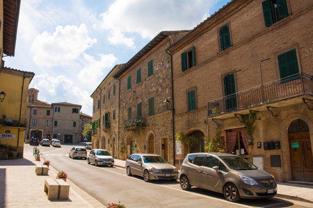 Monticiano, Italy - September 7th 2020. Cars park outside historic buildings in the centre of the medieval town of Monticiano in Siena Province, Tuscany, Italyのeditorial素材