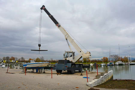 A hydraulic mobile suspended boat lift or hoist with a sling. Located in an out-of-season marina in northern Italyの写真素材