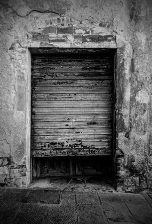 The door of a disused building in the historic medieval village of Batignano, Grosseto Province, Tuscany, Italyの写真素材