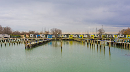 Winter at the marina of an out-of-season beach resort near Grado, Friuli-Venezia Giulia, north east Italy. Chalets can be seen in the background which have been moved to temporary positions whilst infrastructure improvement work is being carried outのeditorial素材