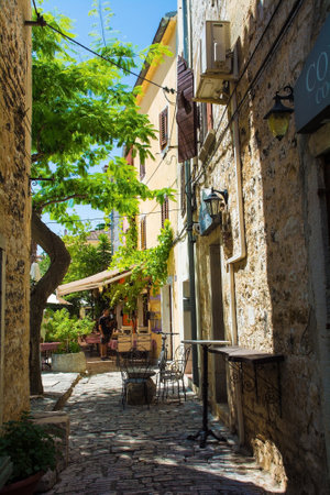 Porec, Croatia- July 10th 2021. A quiet back street with a small bar in the historic medieval coastal town of Porec in Istria, Croatiaのeditorial素材